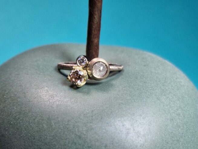 Palladium white gold ring 'Cluster' with a 0,05 ct diamond set into a berry, a 0,31 ct diamond Light Brown in a yellow gold tulip claw setting & a 0,38 ct rose cut Ice diamond. Design by Oogst Jewellery
