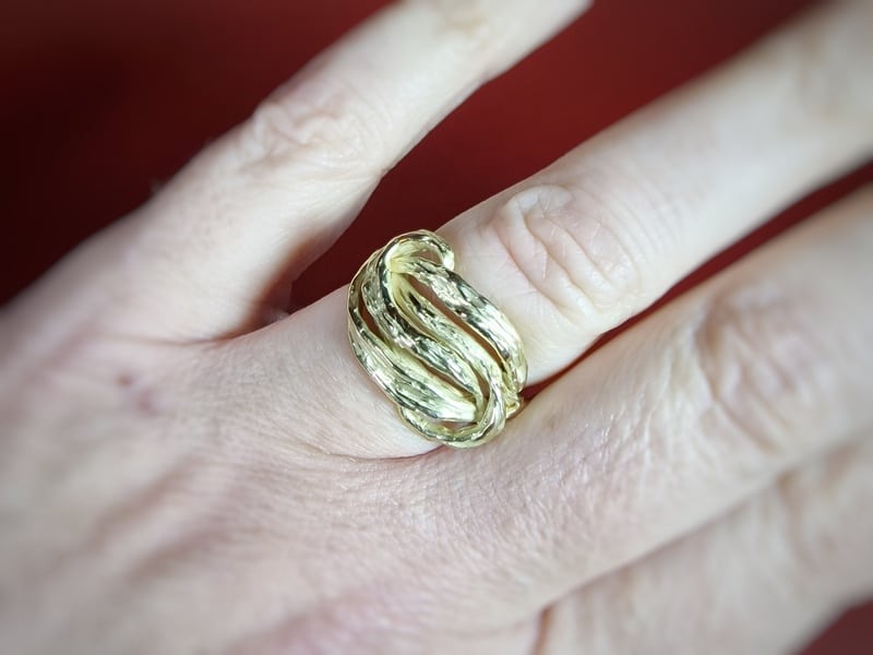 Geelgouden Bladeren ring. Lange golvende bladeren in een knoop vorm. Eenmalig ring van Oogst Goudsmeden. Getoond om de vinger