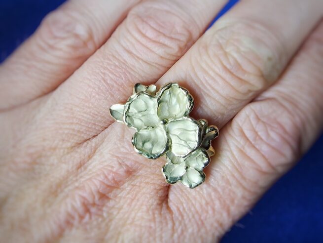 Yellow gold Japonais ring, a sturdy Twig with blossoms and leaves. Original design by oogst Jewellery in Amsterdam. Shown on the finger.