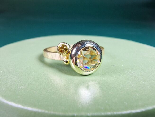 Geelgouden Verzameling ring met een 1,01 ct roosgeslepen diamant en een 0,10 ct briljant geslepen diamant olijf met spitse hamerslag. Ontwerp van Oogst Sieraden in Amsterdam