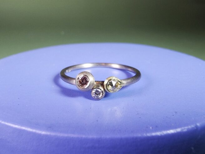 Verlovingsring Verzameling witgouden fijne ring met roosgeslepen diamant, besje en roze diamant in een boleet zetting. Verfijnde verlovingsring. Ontwerp van Oogst Goudsmeden in Amsterdam