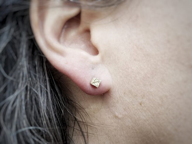 Yellow gold 'Crystals' ear studs. Both are different in shape. The cube crystal. Design by Oogst Jewellery in Amsterdam.