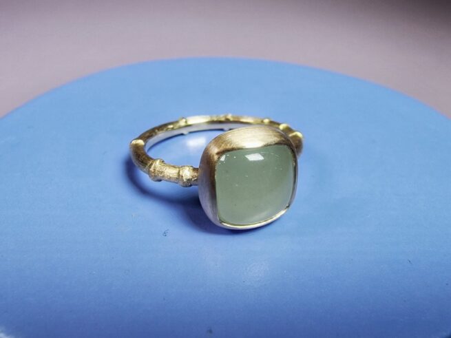 Rosé gold 'Japonais' ring has a bamboo motive and a cushion cabochon cut milky green aquamarine.. Jewellery design by Oogst in Amsterdam