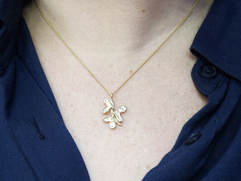 Yellow gold pendant 'Leaves' with heart shaped leaves on a branch. Jewellery design by Oogst goldsmith studio in Amsterdam