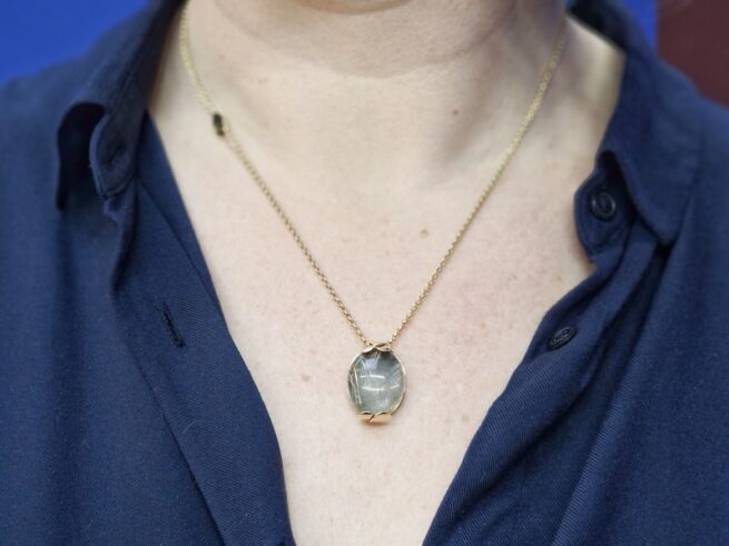 Golden necklace with a rutilated quartz pendant with leaves. Jewellery design by Oogst goldsmith studio in Amsterdam