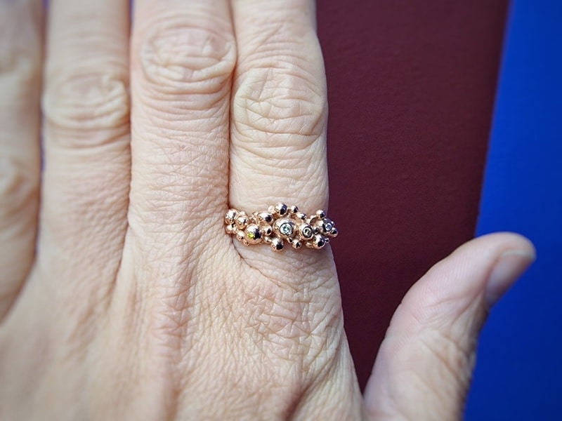 Rose gold ring 'Berries' with sparkling diamonds. Twig ring with playful texture. As seen on the finger. Design by Oogst Jewellery in Amsterdam