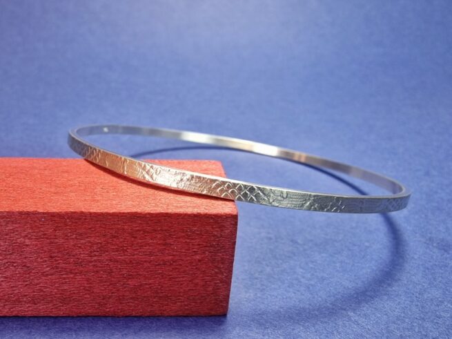 Zilveren armband met structuur van kant. Rinkelband uit het Oogst atelier in Amsterdam