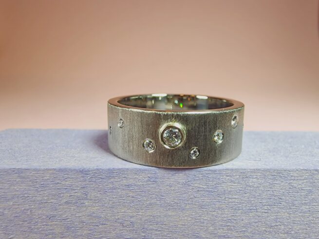 Witgouden ring 'Fluweel' met sterrenhemel diamanten verstrooid in ring gezet. Sieraad ontwerp van Oogst Goudsmeden.