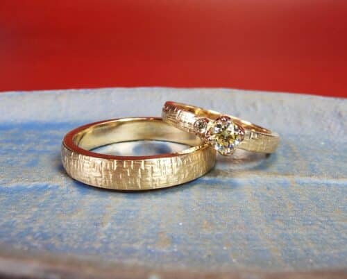 Rosé gold wedding rings with criss cross hammered texture and sparkly diamonds. Designed by Oogst goldsmith Amsterdam.