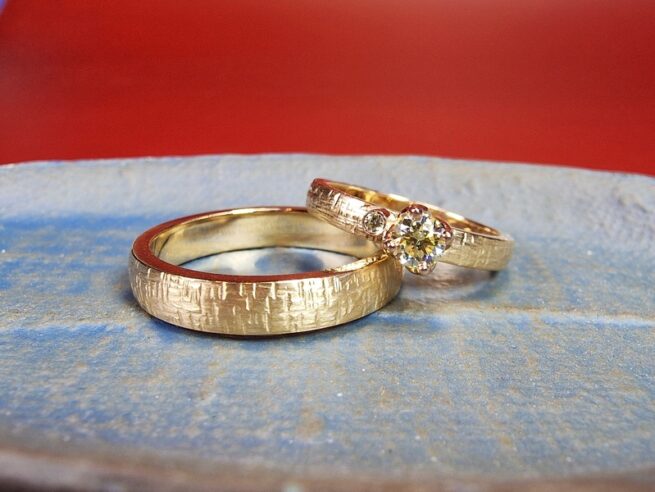 Rosé gold wedding rings with criss cross hammered texture and sparkly diamonds. Designed by Oogst goldsmith Amsterdam.