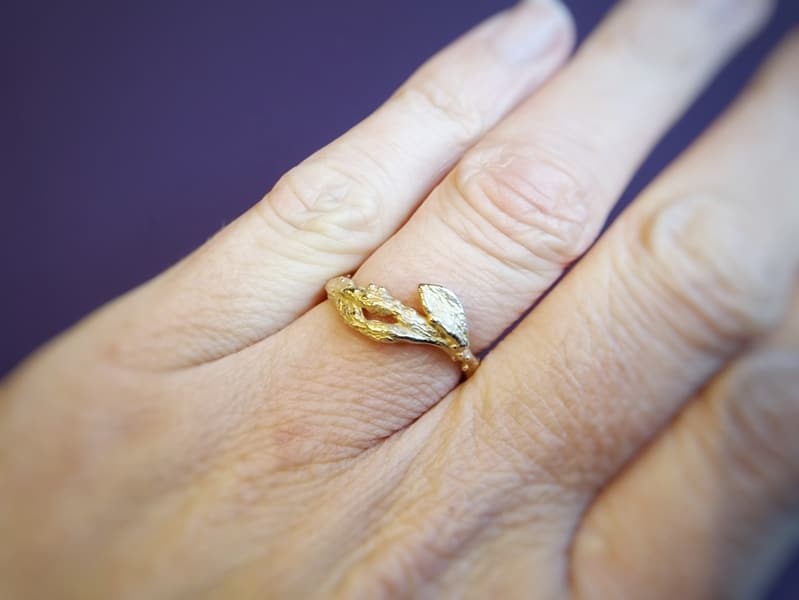 Roségouden ring takjes met blaadje ring om de vinger. Ontwerp van Oogst Goudsmeden in Amsterdam