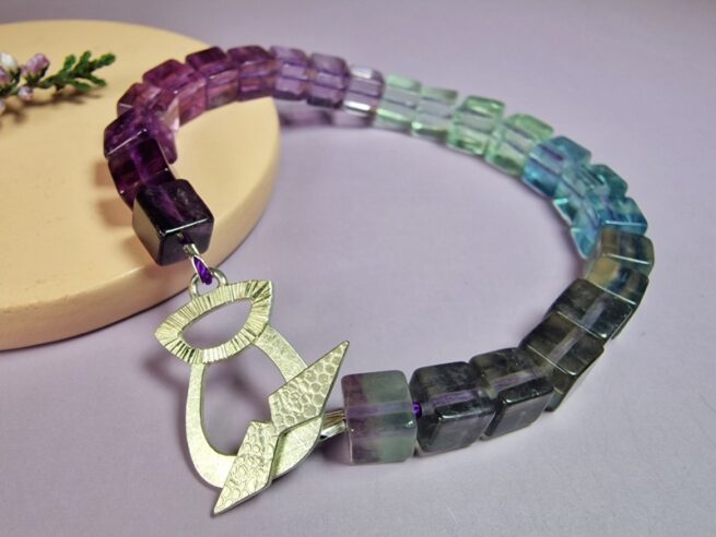 Gemstone bracelet Thistle with fluorite from purple to green and a silver thistle clasp. Oogst Jewellery in Amsterdam.