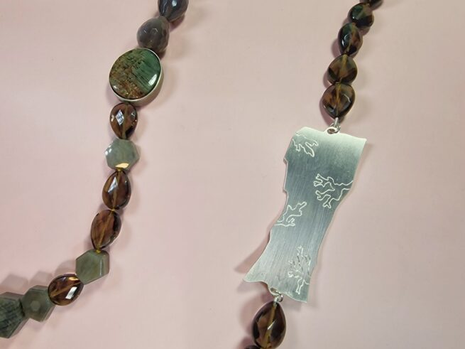 Edelsteen collier met zilveren rotsornament, rutielkwarts, agaat, rookkwarts, saffier, detail van handgravure. Oogst sieraadontwerp in Amsterdam