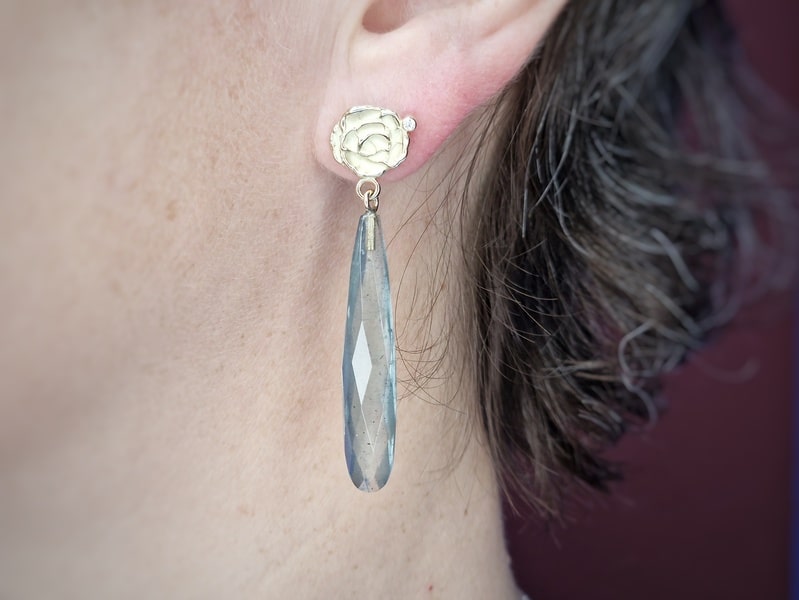 Geelgouden Mackintosh roos oorstekers met briolet mos aquamarijn en diamant. Exclusief paar oorbellen uit het Oogst atelier. In het oor.