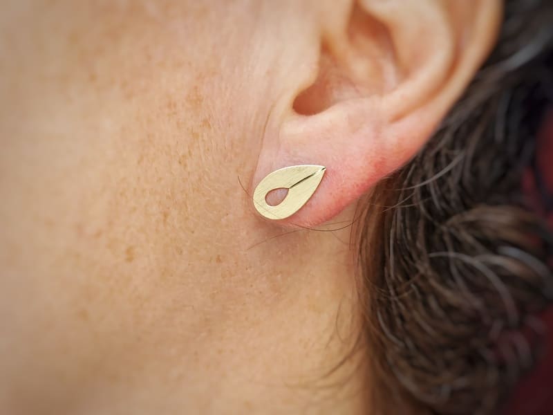 Geelgouden oorstekers druppelblad opengewerkt Mackintosh ornament, in het oor. Oogst Goudsmeden in Amsterdam