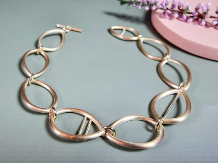 Geelgouden schakel armband opengewerkte Mackintosh ornamenten. Ontwerp van Oogst Goudsmeden in Amsterdam.