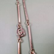 Roodgouden schakelcollier met Mackintosh ornamenten lang en dubbel, detail beeld.
