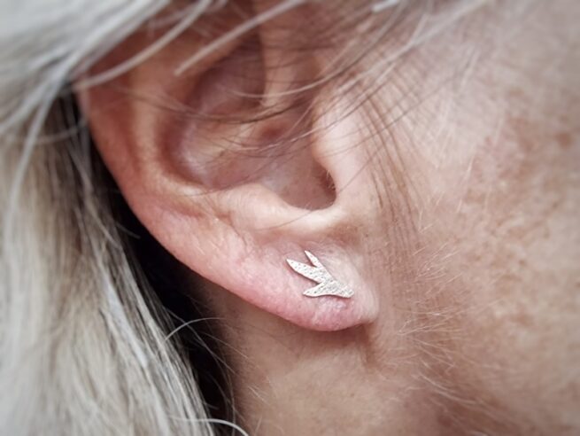 Roségouden Zeewier oorstekertjes. In het oor. Ontwerp van Oogst Sieraden in Amsterdam