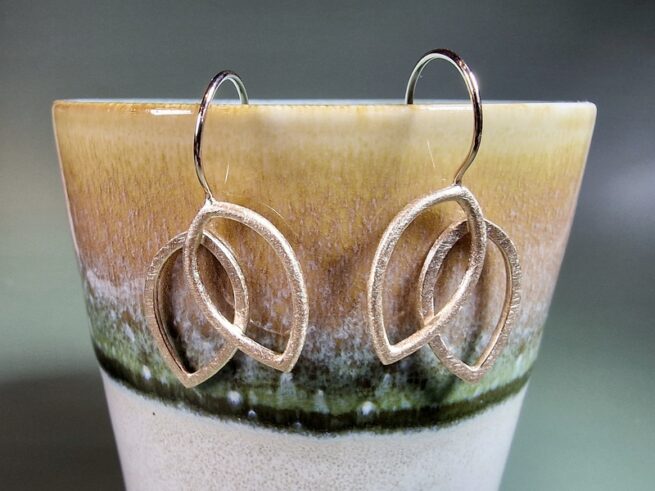 Roségouden oorbellen open bladvormen Mackintosh. Lange oorbellen ontwerp van Oogst Goudsmeden in Amsterdam