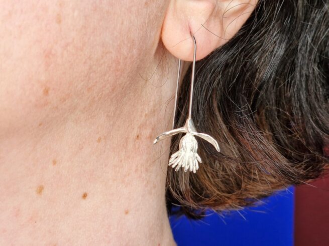 Zilveren distel oorsieraden met lange edelstalen haak. In het oor. Ontwerp van Oogst goudsmid in Amsterdam.