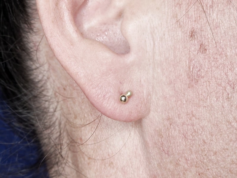 Yellow gold ear studs from the Berries series. Oogst Jewellery in Amsterdam. Seen on the ear.