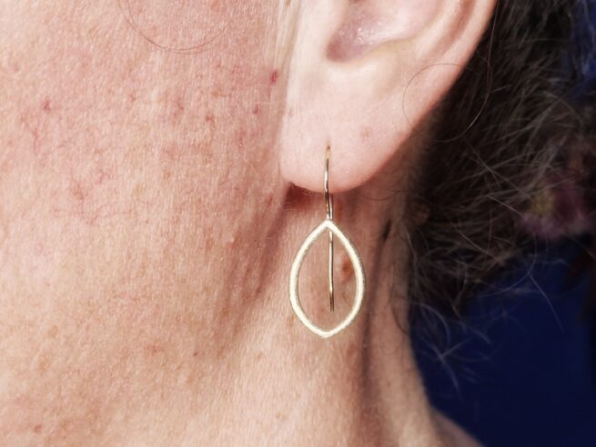 Yellow gold open 'Leaves' earrings from the 'a wee bit of Scotland' series. Design by Oogst in Amsterdam. On the ear.