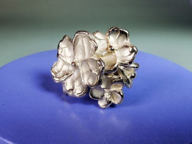Japonais ring. Geelgouden statement ring met bloesems, bloemknoppen en blaadje. Uitgesproken ontwerp uit het Oogst atelier.