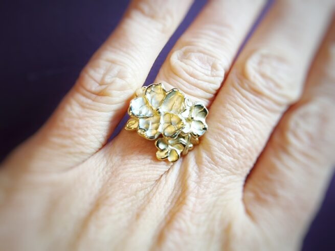 Yellow gold 'Japonais' ring with abundant blossoms, flower buds and a cute leaf. Statement ring by Oogst Jewellery in Amsterdam. On the finger