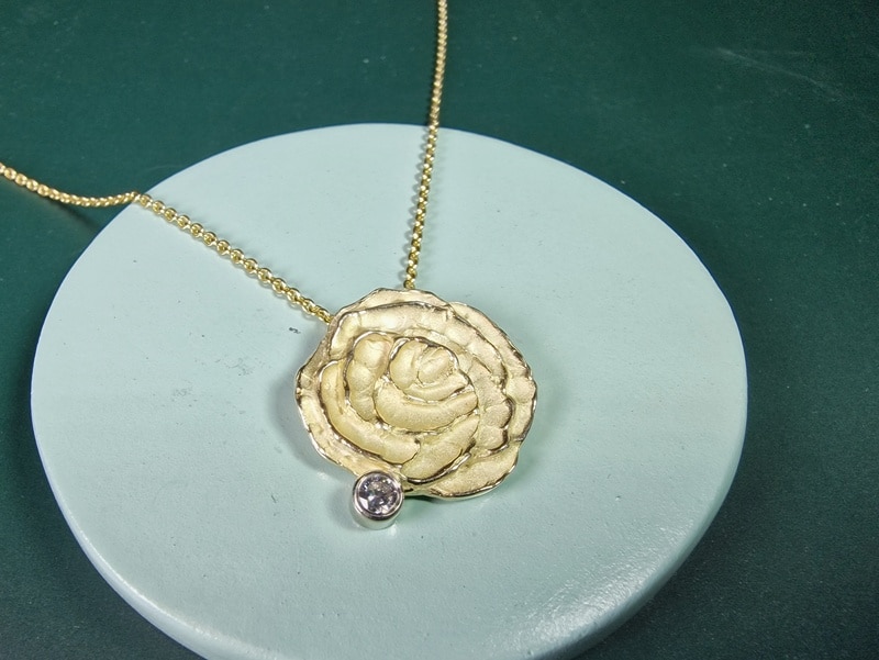 Yellow gold pendant Mackintosh Rose shape with diamond, design by Oogst in Amsterdam. Pendant on a necklace. From the a wee bit of Scotland series