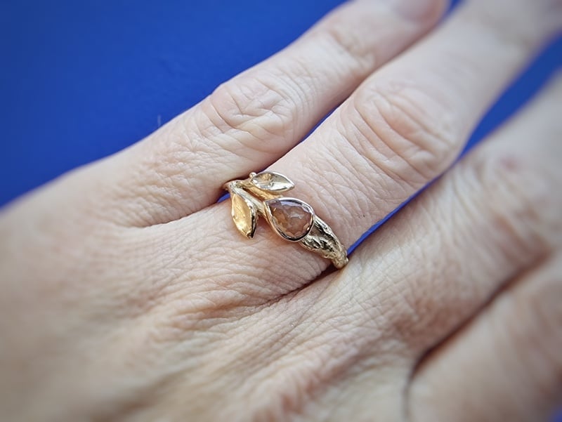 Rosé gold 'Orchard' ring with a warm brown natural diamond. A playful twig with sturdy texture and cute leaves. Design by Oogst Amsterdam. Seen on the finger.