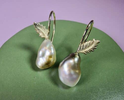 Yellow gold earrings with delicate leaves and Tahitian Keshi pearls. Design by Oogst  Jewellery in Amsterdam