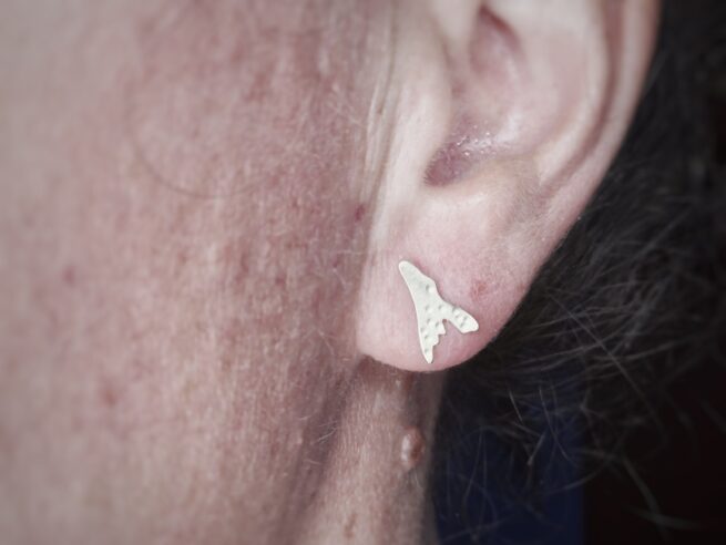 Geelgouden zeewier oorstekers. Speelse textuur en vorm. Oorbel op het oor. Ontwerp van Oogst Sieraden in Amsterdam.