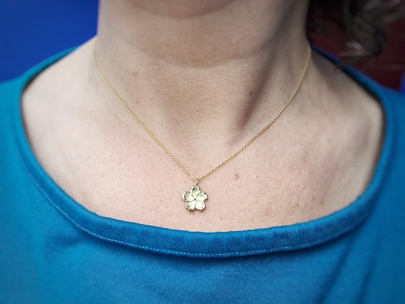 Flower pendant. Yellow gold blossom. As seen on a chain. Oogst Jewellery in Amsterdam