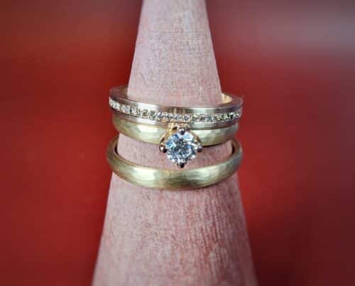 Ritme trouwringen in roségoud met streepjes hamerslag en een Eenvoud ring met diamanten rondom. Bijzondere trouwringen uit het Oogst atelier.