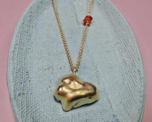 Golden necklace Cloud with an accent of Carnelian. Jewellery design by Oogst in Amsterdam.