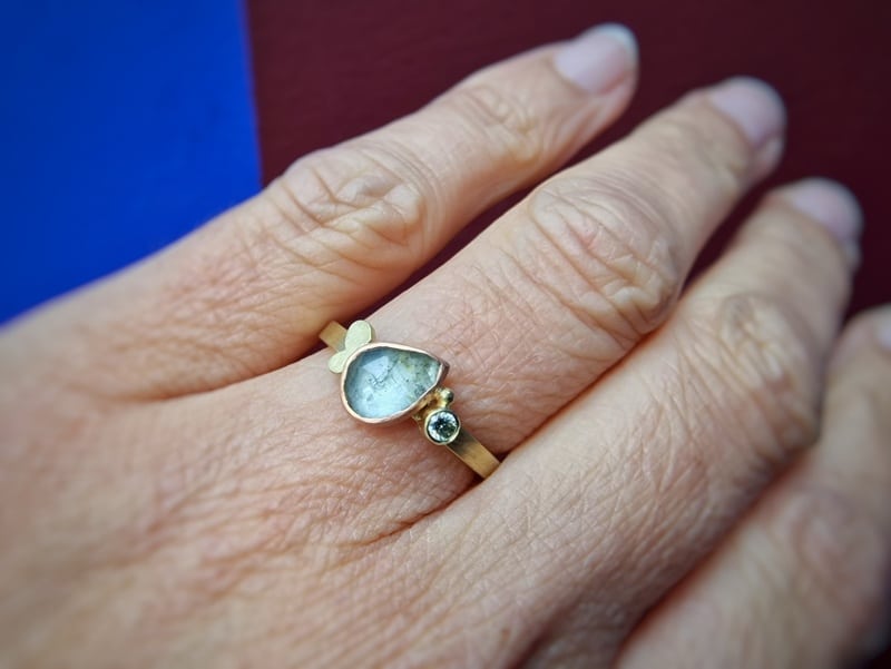 This yellow gold ring with moss aquamarine and diamond is from the 'Cluster' series. Created in the Oogst studio. Seen on the finger.