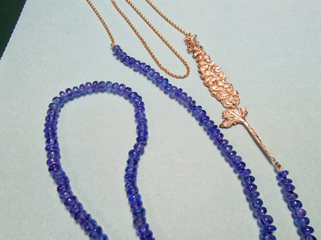 Collier Ridderspoor roodgoud met tanzaniet snoer. Maandbloem van juli. Moderne klassieker van Oogst .