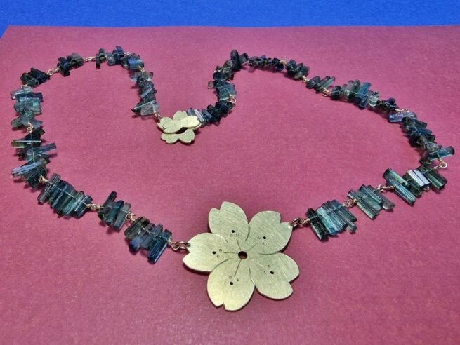 Collier Sakura. De geelgouden kersenbloesem met petrol toermalijn kristallen gecombineerd komt uit de japonais serie van Oogst in Amsterdam.