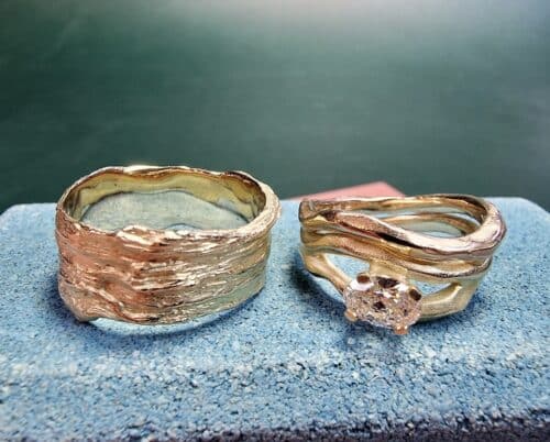 wedding rings 'Wave' & 'Coast'. Yellow gold with sturdy textures and a 0,55 ct oval cut diamond. Standout pair. Oogst jewellery in Amsterdam.