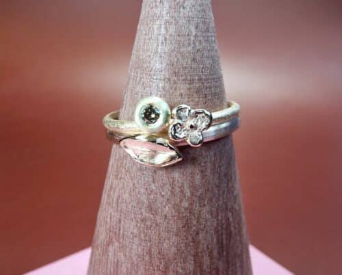 Aanschuifringen 'Blaadjes' en 'In Bloei' Roodgouden ring met roségouden blaadje. Roségouden ring met roodgouden bloempje en in geelgouden boleet zetting een 0,05 ct natuurlijk bruine briljant geslepen diamant. Maatwerk van Oogst Goudsmeden.