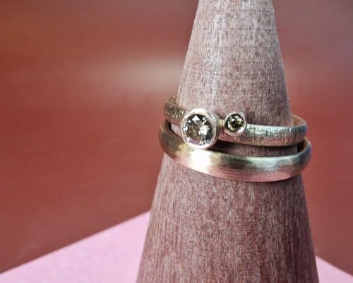 Roségouden trouwringen met gehamerde textuur. Met bruine en olijf diamanten voor haar. Elegant maatwerk paar. Uit het Oogst atelier.