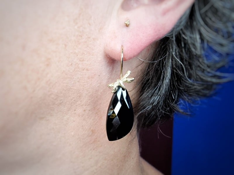 Geelgouden Libelle oorsieraden met zwarte spinel in het oor. Uit de Insecten serie van Oogst Goudsmeden.