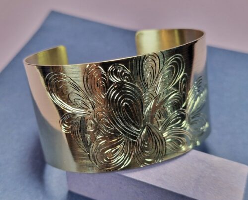 Geelgouden brede klemarmband met handgravure tekening van krullen. Uit de Lineair serie van Oogst, maatwerk variant.
