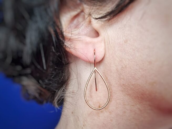 Roodgouden oorsieraden Druppel met krul, in het oor. Uit het Oogst atelier.