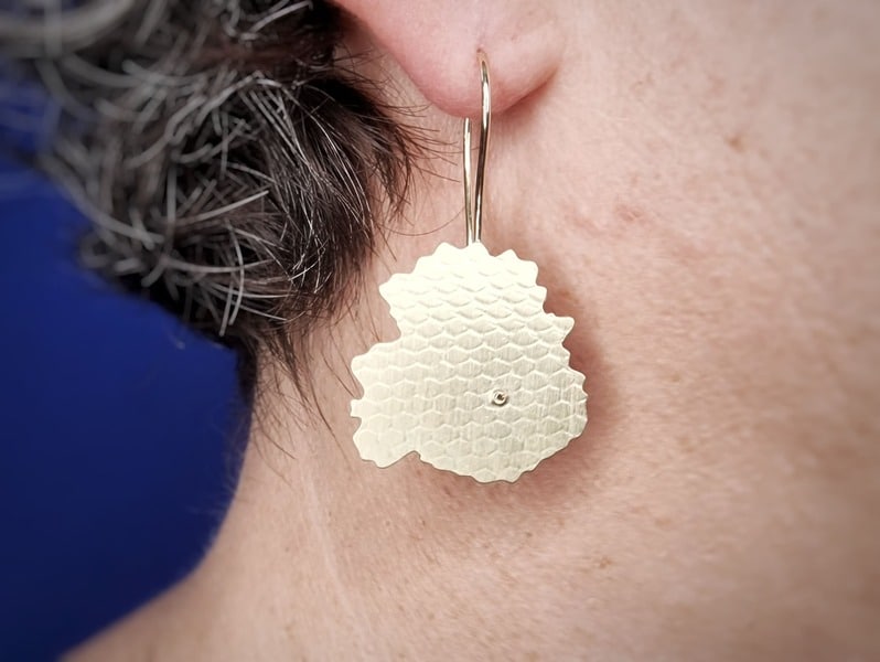 Geelgouden oorsieraden Zwammen met diamant, grafische vorm. Uit het goudsmid atelier van Oogst, in het oor.
