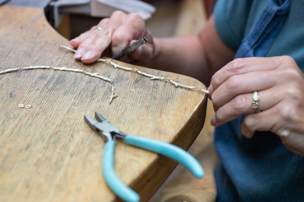 Goldsmith working in the Oogst studio. Creating a necklace.