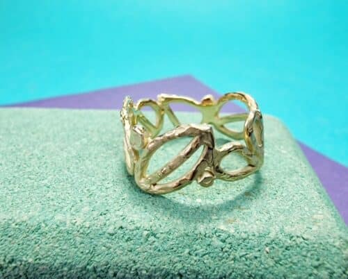 Mackintosh ring in geelgoud. Met open motieven van blaadjes en cirkels rondom. Uit het Oogst atelier.