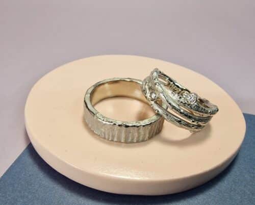 Original white gold wedding rings with sturdy textures. For her gradient twigs with sparkling diamonds, for him a robust look. Bespoke pair created by Oogst.