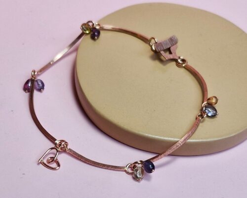 Rose gold Mackintosh bracelet with hammered texture and dangling sapphires. Elegant design by Oogst. Elegant design by Oogst. 