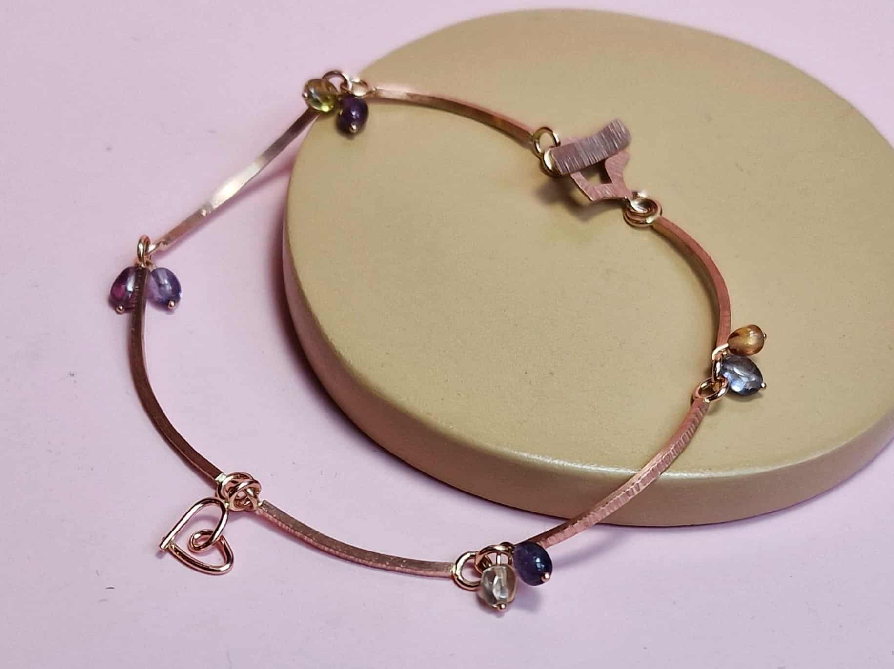 Roodgouden schakel armband met saffier en Mackintosh elementjes. met gehamerde textuur. Elegant ontwerp van Oogst Goudsmeden.